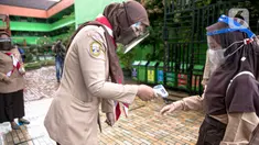 Guru memeriksa suhu tubuh siswa saat hari pertama uji coba Pembelajaran Tatap Muka (PTM) di SDN Kenari 08 Pagi, Jakarta, Rabu (7/4/2021). Pemprov DKI Jakarta mulai melakukan uji coba pembelajaran tatap muka secara terbatas di 100 sekolah mulai 7 hingga 29 April 2021. (Liputan6.com/Faizal Fanani)