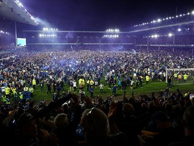 Suporter Everton menyerbu lapangan untuk merayakan akhir pertandingan Liga Inggris antara Everton dan Crystal Palace di Goodison Park di Liverpool, Inggris, 19 Mei 2022. Everton berhasil menang lewat come back dramatis 3-2 dan keluar dari zona degradasi Liga Inggris. (AFP/Oli Scarff)