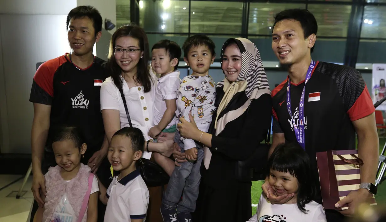 Pasangan ganda putra Indonesia, Mohammad Ahsan/Hendra Setiawan, berfoto bersama keluarga usai konfrensi pers di Bandara Soekarno-Hatta, Tangerang, Selasa (27/8). Ahsan/Hendra meraih gelar pada Kejuaraan Dunia Bulutangkis 2019. (Bola.com/Yoppy Renato)