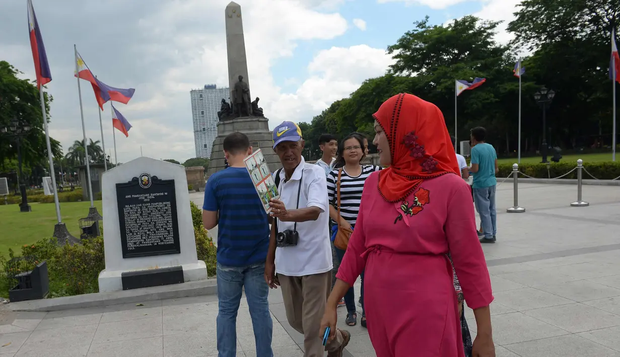 Fotografer taman, Joel Estrella menawarkan jasa foto kepada wisatawan di sebuah taman di Manila, Filipina (22/4). Estrella telah bekerja sebagai fotografer taman sejak tahun 1970. (AFP Photo/Ted Aljibe)