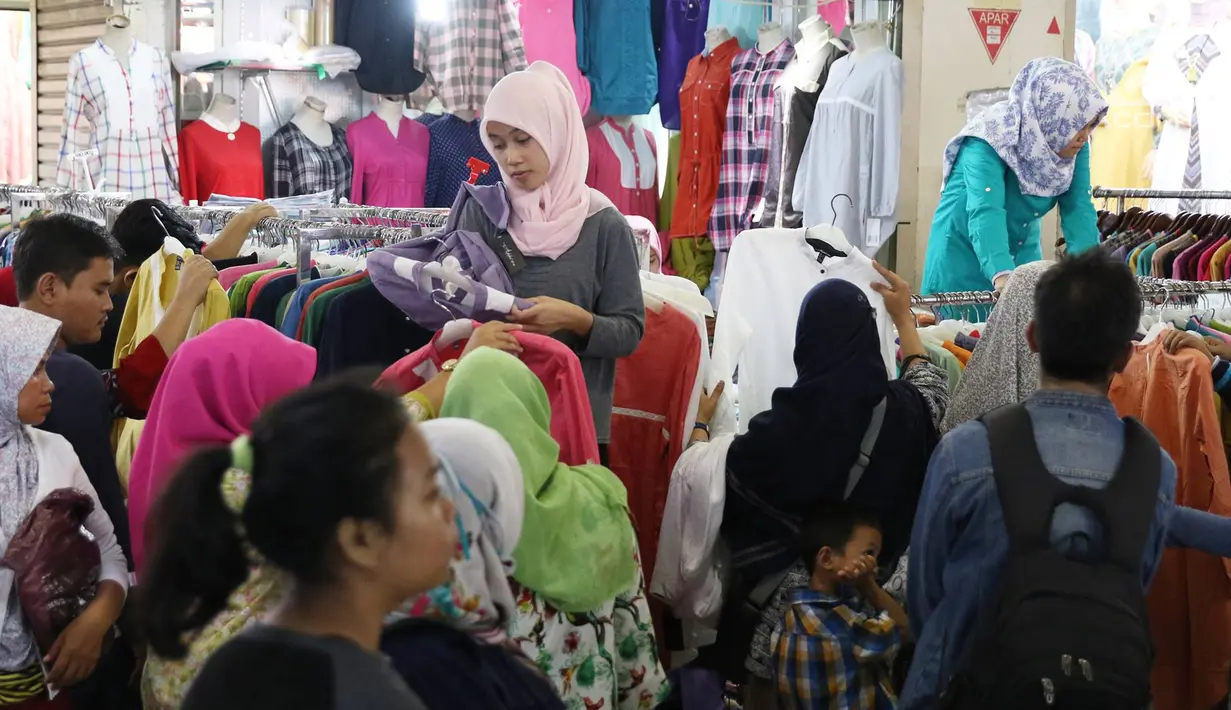 Sejumlah calon pembeli memilih pakaian di Pasar Tanah Abang, Jakarta, Minggu (18/6). Salah satu pedagang mengaku, omzet penjualannya tahun ini jauh meningkat drastis sejak sebulan sebelum Ramadan. (Liputan6.com/Immanuel Antonius)