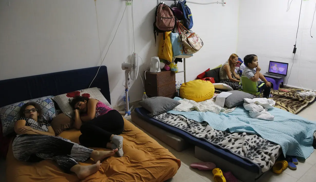 Warga berlindung dari serangan roket di shelter bom Kota Ashkelon, Israel, Rabu (13/11/2019). Militan Palestina menghujani Israel dengan roket sebagai balasan atas tewasnya komandan Jihad Islam Palestina Baha Abu Al-Ata dalam serangan udara Israel. (GIL COHEN-MAGEN/AFP)