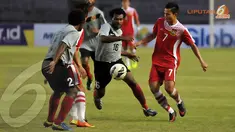 Pemain Papua Nugini Sengum Maximillion (nomor 16) berusaha merebut bola dari penguasaan pemain Laos Khonesavanh Sihavong (Liputan6.com/Helmi Fithriansyah)