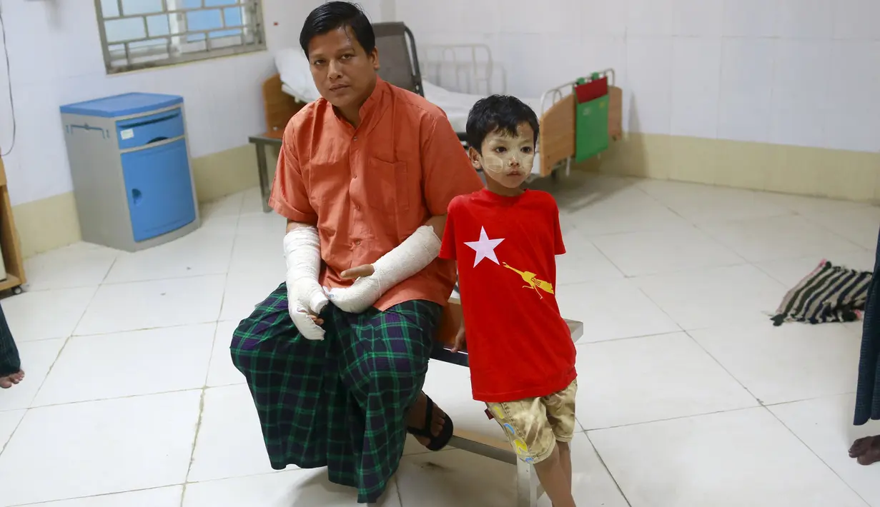 Naing Nan Lynn bersama anaknya saat dirawat di Rumah Sakit, Yangon, Myanmar,  Rabu (4/11/2015). Anggota Oposisi Myanmar ini menderita luka serius setelah dipukul di kepala dan lengannya. (REUTERS/Soe Zeya Tun)