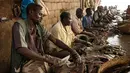 Sejumlah pedagang memotong ikan di sebuah pasar ikan di dekat Sungai Nil, di kota kembar Khartoum, Omdurman (24/6/2019). Kota Omdurman didirikan pada tahun 1884. (AFP Photo/Yasuyoshi Chiba)