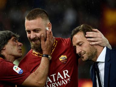 Gelandang AS Roma, Daniele De Rossi, bersama Bruno Conti dan Francesco Totti usai melawan Parma pada laga Serie A di Stadion Olympic, Roma, Minggu (26/5). Laga ini perpisahan bagi De Rossi dan AS Roma setelah 18 tahun. (AFP/Filippo Monteforte)