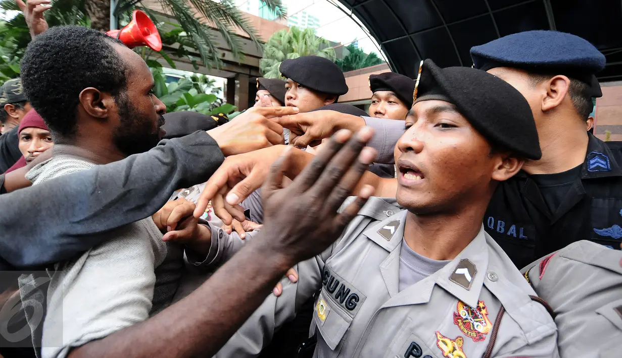 Massa yang tergabung dalam Aliansi Mahasiswa Papua dan FRI-West Papua terlibat saling dorong dengan polisi saat aksi di Jakarta, Jumat (7/4). Mereka menuntut penutupan PT Freeport. (Liputan6.com/Helmi Fithriansyah)