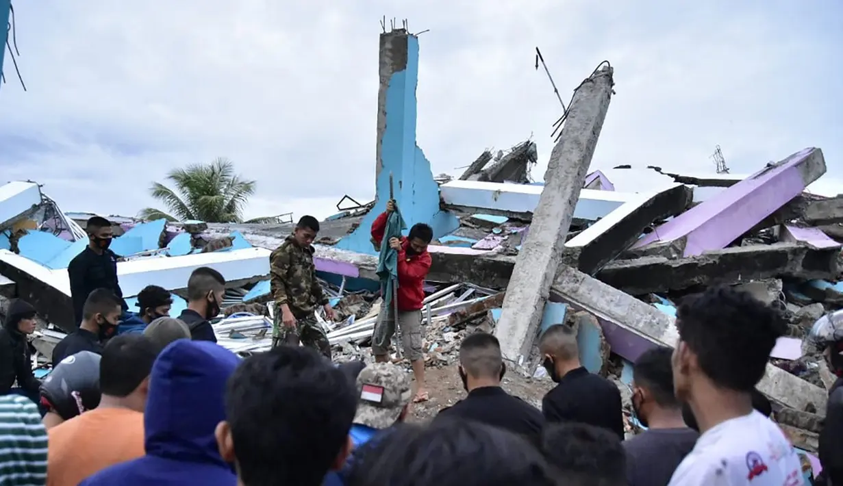 Tim penyelamat mencari korban usai gempa meruntuhkan Rumah Sakit Mitra Manakarra, Kota Mamuju, Sulawesi Barat, Indonesia, Jumat (15/1/2021). Sebanyak 20 pasien dan staf terjebak di bawah reruntuhan bangunan. (Firdaus/AFP)