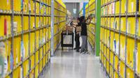 Pekerja memindai barang ketika mencari pesanan pelanggan di pusat gudang toko online Amazon usai resmi dibuka di Singapura, Kamis (27/7). Amazon telah meluncurkan layanan pengiriman Amazon Prime Now di Negeri Singa itu. (AP Photo/Joseph Nair)