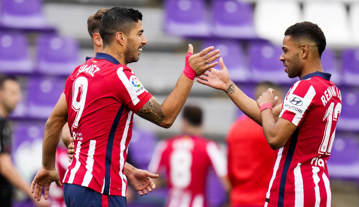 Striker Atletico Madrid, Luis Suarez, melakukan selebrasi bersama Renan Lodi usai mencetak gol ke gawang Real Valladolid pada laga Liga Spanyol di Stadion Jose Zorrilla, Sabtu (22/5/2021). Atletico Madrid menang dengan skor 2-1. (AP/Manu Fernandez)