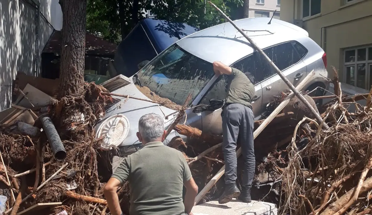 Orang-orang berupaya mengevakuasi mobil dari puing-puing setelah diterjang banjir di Provinsi Giresun, kawasan Laut Hitam, Turki (23/8/2020). Banjir yang melanda Giresun pada Minggu (23/8) menewaskan enam orang, termasuk dua personel Gendarmerie. (Xinhua)