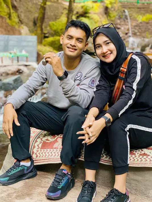 Bersama sang suami mengenakan outfit hitam-hitam lengkap dengan hijab. Kalau saat dipanggung kerap tampil glamour, dikesehariannya kerap tampil sederhana. [Instagram/khrisnashakti]