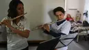 Dua orang relawan dari Musica Para el Alma memainkan alat musiknya di Rumah Sakit Alvarez di Buenos Aires, Argentina (12/6). Mereka juga sering tampil di sekolah pendidikan khusus, panti jompo dan institusi publik lainnya. (AFP Photo/Eitan Abramovich)