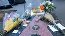 Penggemar meletakkan karangan bunga dan memorabilia lainnya di atas bintang Walk of Fame milik pencipta sekaligus legenda komik-komik Marvel, Stan Lee di Hollywood, California, Senin (12/11). Stan Lee meninggal dunia pada usia 95. (VALERIE MACON / AFP)
