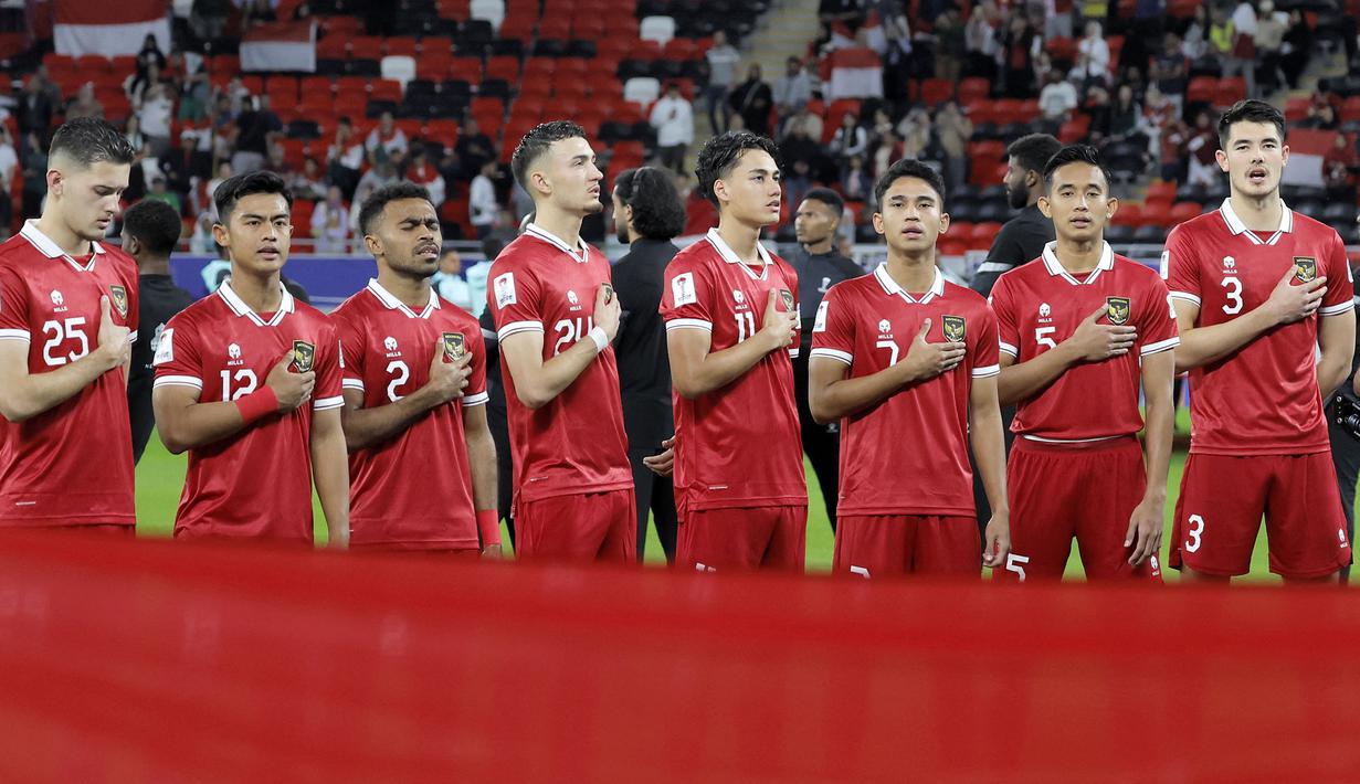 Para pemain starting XI Timnas Indonesia berbaris menyanyikan lagu kebangsaan Indonesia Raya sebelum dimulainya laga pertama Grup D Piala Asia 2023 Qatar menghadapi Timnas Irak di Ahmad bin Ali Stadium, Al-Rayyan, Doha, Senin (15/1/2024). (AFP/Karim Jaafar)
