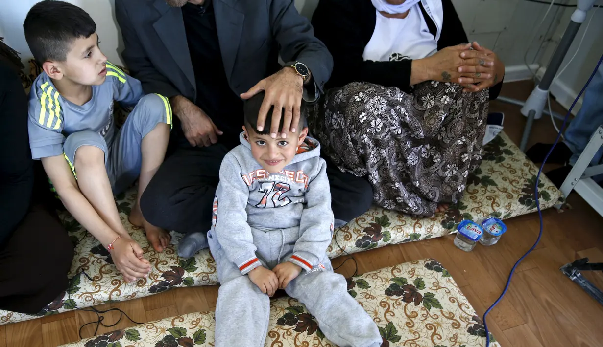 Murad dan adiknya Emad duduk bersama orang tuanya di rumahnya di kamp pengungsian dekat Kota Duhok, Irak, pada 19 April 2016. Sejumlah anak laki-laki Yazidi dipaksa mengikuti latihan untuk menjadi penerus militan ISIS. (REUTERS / Ahmed Jadallah)