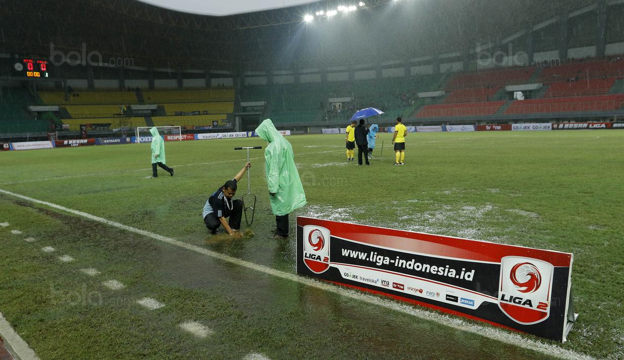 Petugas membuat lubang resapan untuk menguras air yang menggenangi lapangan di Stadion Patriot, Bekasi, Senin (13/11/2017). Drainase yang buruk menyebabkan lapangan terendam air. (Bola.com/M Iqbal Ichsan)