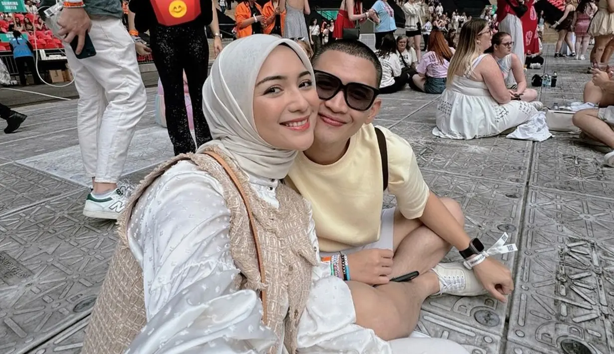 Nonton konser bareng, Citra Kirana dan Rezky Aditya bak ABG. Citra Kirana stylish dengan blouse, celana, dan jilbab warna putih ditambah dengan vest warna cokelat. Sementara Rezky Aditya simpel dengan baju kaus dan celana warna putih. Seperti diketahui, konser Taylor Swift di Inggris ini digelar di Wembley Stadion, London pada tanggal 15 sampai 20 Agustus 2024. (Liputan6.com/IG/@citraciki)