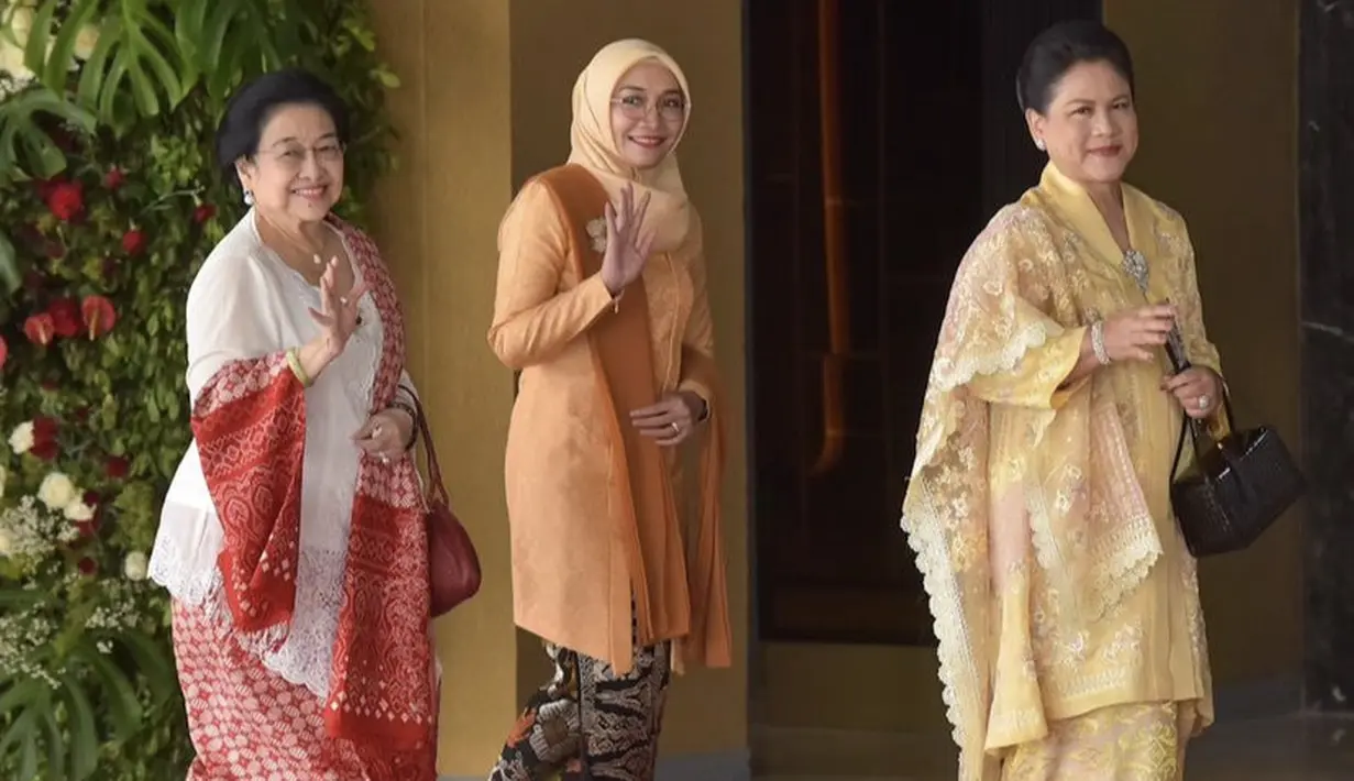 Istri wakil Presiden, Wury Estu Handayani tampil dibalut kebaya lengan panjang warna oranyw serasi dengan selendang dan kerudungnya. Dipadukan kain motif Bali sebagai bawahannya. [Instagram/@sekretariat.kabinet]