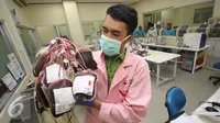 Petugas memperlihatkan kantong darah di kantor PMI DKI Jakarta, Jumat (24/6). Meskipun terdapat penurunan, namun stok darah di Ibu Kota relatif aman selama Ramadan dengan jumlah sekitar 800-1.500 kantong perhari. (Liputan6.com/Immanuel Antonius)
