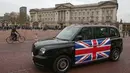 Taksi listrik, TX eCity diuji jalankan dekat Istana Buckingham di London, Inggris, Selasa (5/12). Taksi hitam bertenaga listrik tersebut disebut-sebut merupakan yang pertama di London. (AFP PHOTO / Daniel LEAL-OLIVAS)