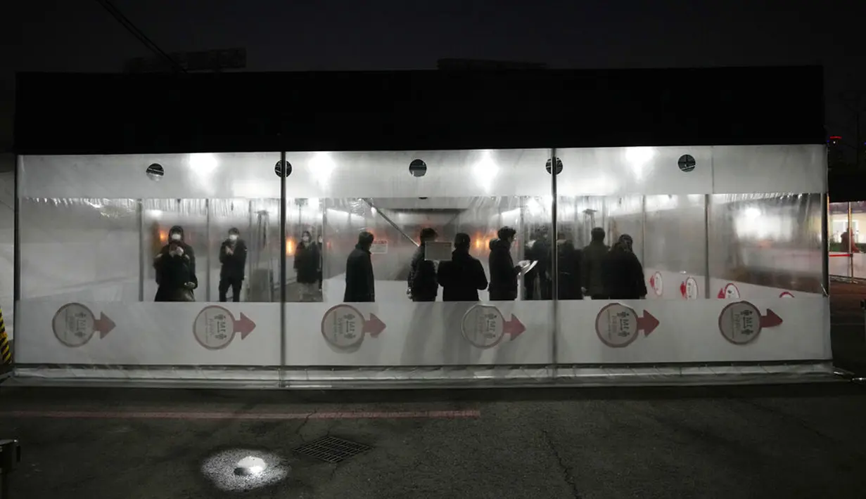 Orang-orang menunggu tes virus corona COVID-19 di tempat pengujian darurat, Seoul, Korea Selatan, Rabu (26/1/2022). Korea Selatan mengurangi periode karantina dan perluasan pengujian cepat menyusul melonjaknya kasus COVID-19. (AP Photo/Ahn Young-joon)