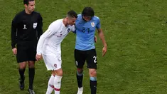 Penyerang Portugal, Cristiano Ronaldo membantu Edinson Cavani yang Cedera keluar lapangan saat pertandingan babak 16 besar Piala Dunia 2018 di Stadion Fisht di Sochi, Rusia (30/6). Cavani cedera kisaran menit ke 70. (AP Photo/Darko Vojinovic)