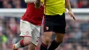 Pemain Arsenal, Shkodran Mustafi berebut bola dengan pemain  Watford Troy Deeney pada lanjutan pertandingan Liga Inggris di Emirates Stadium, Minggu (11/3). Kemenangan telak sukses dibukukan Arsenal usai mengalahkan Watford 3-0. (Ben STANSALL / AFP)