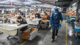 Pekerja menyemprotkan disinfektan di ruang produksi Hangzhou Jiefeng Garments Co. Ltd. di Hangzhou, Provinsi Zhejiang, China, Rabu (12/2/2020). Di bawah arahan dan dukungan otoritas setempat, banyak perusahaan di Zhejiang kembali beroperasi setelah melakukan pencegahan virus corona. (Xinhua/Xu Yu)