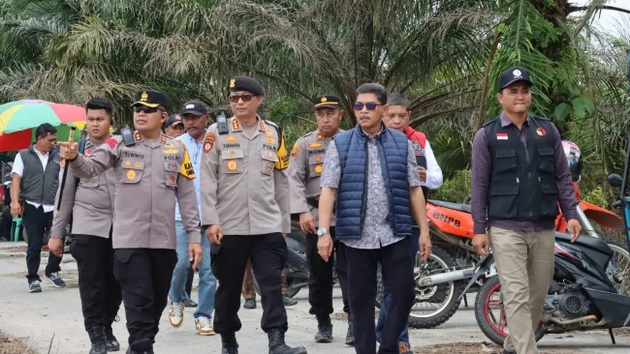 Kapolres Pelalawan AKBP Suwinto bersama polisi lainnya menuju TPS untuk melihat proses pencoblosan.