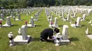 Warga Korea Selatan, Oh Myung-Soon menangis di depan batu nisan saudaranya yang meninggal selama Perang Korea di pemakaman nasional, Seoul, Korea Selatan, Rabu (6/6). Kegiatan ini dilakukan dalam Memorial Day. (AP Photo/Ahn Young-joon)