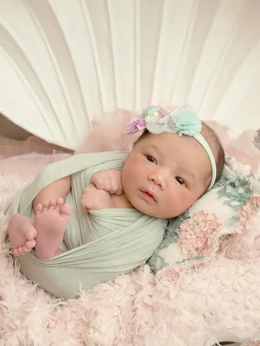 <p>Baby Aura makin menggemaskan dengan bando yang melingkar di kepalanya. Baby Azura cantik dan menggemaskan warganet. [Instagram/azuraatta]</p>