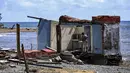 Seorang pria berdiri di samping sebuah rumah yang rusak akibat Badai Melissa di desa Boca de Dos Rios, provinsi Santiago de Cuba, Kuba pada Kamis 30 Oktober 2025. Sementara, kerusakan terparah dilaporkan terkonsentrasi di wilayah barat daya dan barat laut. (YAMIL LAGE/AFP)