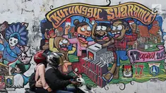 Kendaraan melintasi mural bertema Pemilu 2019 di kawasan Dukuh Atas, Jakarta, Senin (1/4). Mural-mural tersebut dibuat dalam rangka menyukseskan Pemilu yang akan berlangsung pada 17 April 2019 mendatang. (Liputan6.com/Immanuel Antonius)