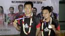 Pasangan ganda putra Indonesia, Mohammad Ahsan/Hendra Setiawan, menunjukan mendali saat konfrensi pers di Bandara Soekarno-Hatta, Tangerang, Selasa (27/8). Ahsan/Hendra meraih gelar pada Kejuaraan Dunia Bulutangkis 2019. (Bola.com/Yoppy Renato)