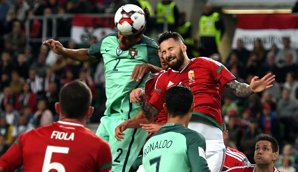 Bek Portugal, Bruno Alves, duel udara dengan bek Hongaria, Tamas Kadar, pada laga Kualifikasi Piala Dunia 2018 di Stadion Groupama, Minggu (3/9/2017). Portugal menang 1-0 atas Hongaria. (AFP/Attila Kisbenedek)
