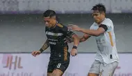 Striker Dewa United, OJ Porteria mencoba lepas dari pengawalan bek Madura United, Fachrruddin Aryanto dalam laga lanjutan BRI Liga 1 2023/2024 di Indomilk Arena, Tangerang, Banten, Kamis (25/4/2024) petang WIB. (Dok. Dewa United)