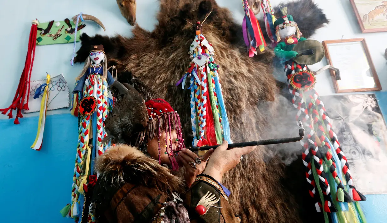Seorang dukun dari kelompok Adyg Eeren (Roh Beruang) melakukan ritual mistis untuk mengusir roh-roh jahat di kediaman pelanggannya di Kota Kyzyl, Tuva, Siberia, Rusia, (3 /11). (REUTERS/Ilya Naymushin)
