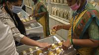 Seorang pelanggan (kiri) memeriksa gelang emas selama festival Hindu 'Akshaya Tritiya', hari keberuntungan dalam kalender Hindu untuk membeli barang-barang berharga, di ruang pamer perhiasan di Chennai, India, Selasa (3/5/2022). Membeli emas adalah kegiatan yang populer di Akshaya Tritiya, karena ini adalah simbol utama kekayaan dan kemakmuran. (Arun SANKAR / AFP)