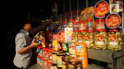 Seorang pria melihat dagangan kue kering di salah satu toko penjualan kue kering di kawasan Ciracas, Jakarta, Selasa (19/5/2020). Adanya pandemi covid-19 diakui para pedagang menyebabkan penjualan kue kering menjelang lebaran turun hingga 50 persen. (Liputan6.com/Immanuel Antonius)
