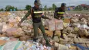 Petugas membawa produk kosmetik palsu untuk dimusnahkan di Phnom Penh, Kamboja (3/10). Pada bulan Mei, pihak berwenang Kamboja menyita 68 ton produk kosmetik palsu yang dibuat di negara-negara seperti Jepang dan Korsel. (AFP Photo/Tang Chhin Sothy)