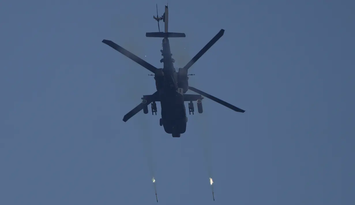 Helikopter serang Apache AH-64 Angkatan Darat Amerika Serikat menembakkan roket ke sasaran saat latihan militer gabungan Super Garuda Shield 2022 di Baturaja, Sumatera Selatan, Indonesia, Jumat (12/8/2022). Bergabung untuk pertama kalinya dalam latihan ini adalah peserta dari negara mitra lainnya termasuk Australia, Jepang, dan Singapura. (AP Photo/Dita Alangkara)