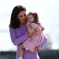 Kate Middleton menggendong sambil menghibur anaknya, Putri Charlotte, saat mengunjungi Pabrik Airbus di Hamburg, 21 Juli 2017. Putri Charlotte mendadak merajuk dan enggan naik helikopter di pabrik pesawat terbang itu. (Christian Charisius / POOL / AFP)