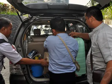 Petugas KPK menurunkan sejumlah barang hasil penggeledahan rumah  mantan Gubernur Papua Barnabas Suebu dari dalam mobil, Jakarta, (22/10/14). (Liputan6.com/Miftahul Hayat)