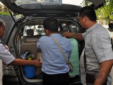 Petugas KPK menurunkan sejumlah barang hasil penggeledahan rumah  mantan Gubernur Papua Barnabas Suebu dari dalam mobil, Jakarta, (22/10/14). (Liputan6.com/Miftahul Hayat)