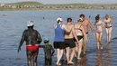 Sejumlah wisatawan berjalan di tepi Danau Tus, Khakassia, Siberia Krasnoyarsk, Rusia (18/7/2015). Danau Tus terkenal akan lumpurnya yang kaya mineral sehingga diyakini bisa menyembuhkan beberapa penyakit. (REUTERS/Ilya Naymushin)