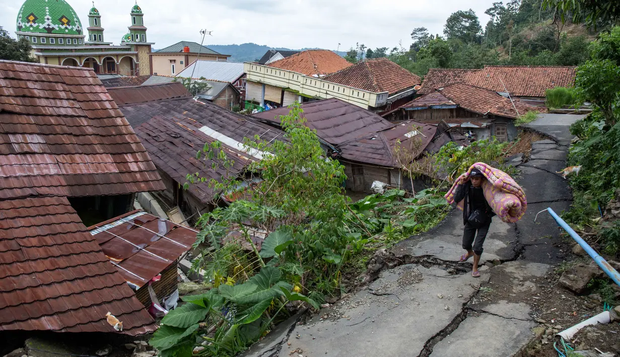 Dari jumlah tersebut, terdapat 220 warga lanjut usia (lansia), 3 ibu hamil, 3 ibu menyusui, 179 anak-anak, 40 balita, 65 batita, 1.049 remaja, dan 894 dewasa. Tampak dalam foto, Seorang pria menyelamatkan barang-barangnya setelah pergerakan tanah melanda permukiman mereka di desa Padasari, Tegal, Jawa Tengah, Senin 9 Februari 2026. (DEVI RAHMAN/AFP)
