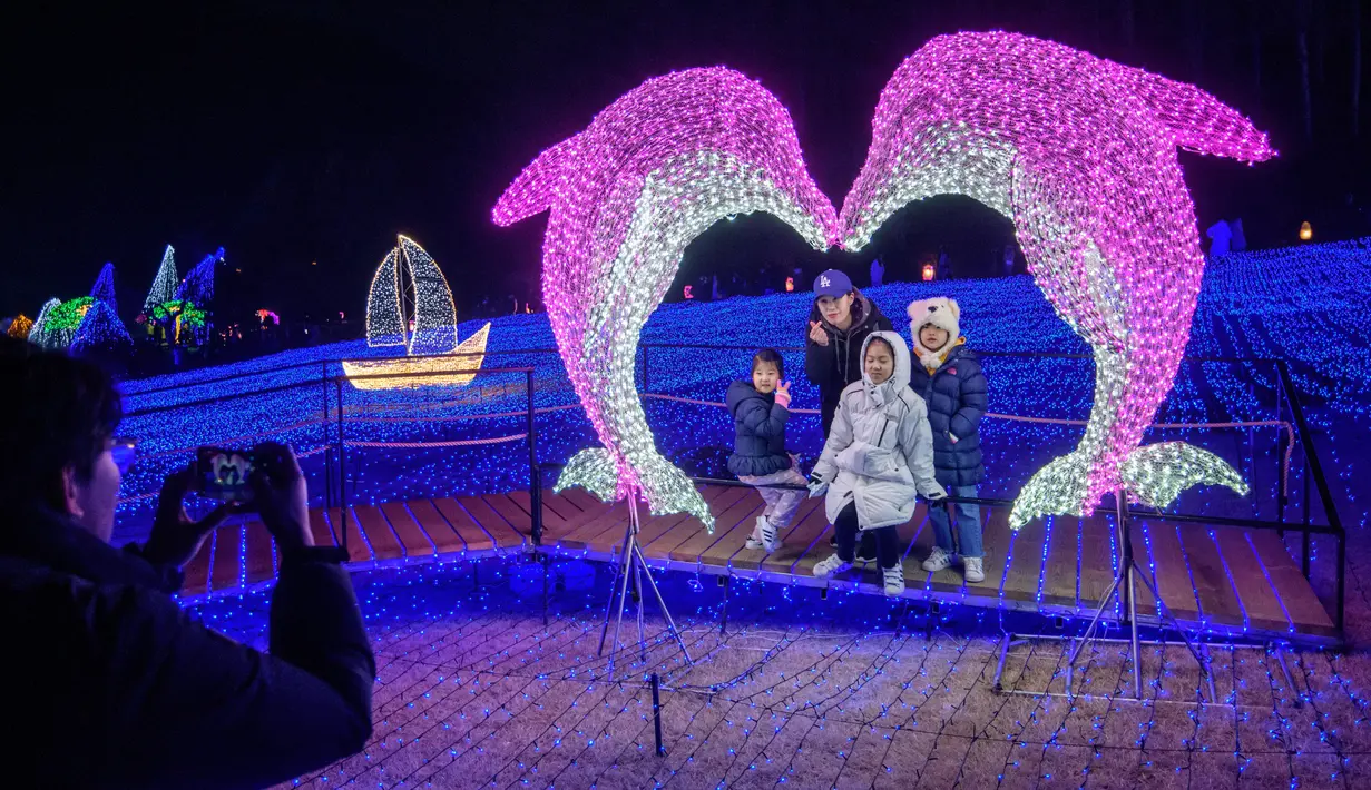Gambar yang diambil 11 Januari 2020, pengunjung melihat tampilan beragam kerlip lampu di Garden of Morning Calm, sebelah timur Seoul di distrik Gapyeong, Korea Selatan. Festival cahaya tahunan tersebut dinikmati saat musim dingin, Desember sampai akhir bulan Maret. (Ed JONES / AFP)
