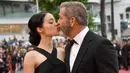 Aktor senior Mel Gibson mencium bibir pacar barunya, Rosalind Ross saat menghadiri acara penutupan Festival Film Cannes, Prancis, 22 Mei 2016.  Seperti yang diketahui, usia Mel Gibson dan kekasih cantiknya terpaut 35 tahun. (Anne-CHRISTINE POUJOULAT/AFP)