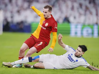 Pemain FC Copenhagen, Kevin Diks, berebut bola dengan pemain Galatasaray, Kerem Akturkoglu, pada laga Liga Champions (12/12/2023). Kevin Diks menjadi buah bibir karena mampu mengantarkan Copenhagen lolos ke babak 16 besar Liga Champions. (AFP/Liselotte Sabroe)